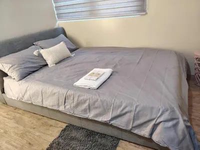 a bed with a blanket and a book on it at NestAway Condo in Manila
