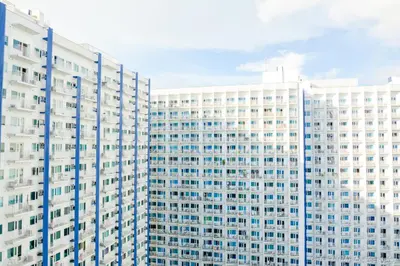 a group of white buildings with blue windows at The Soft Stay 1BR SM Jazz Makati in Manila