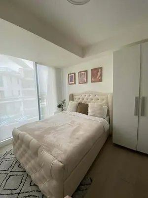 a large bed in a bedroom with a large window at penthouse condo in Azure - near airport in Manila