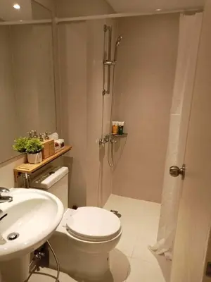 a bathroom with a shower and a toilet and a sink at staycation at azure - near airport in Manila