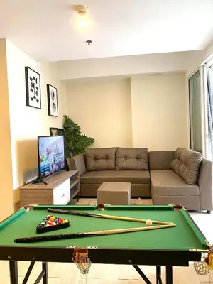 a living room with a pool table and a couch at staycation at azure - near airport in Manila