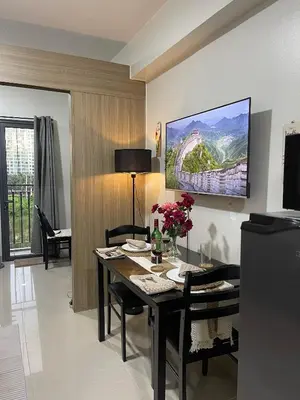 a dining room with a table with flowers on it at Heartline Homes Shore 2 Residences in Manila