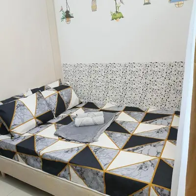 a bedroom with a bed with a black and white tiling at Luxx Place in Manila