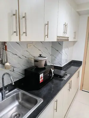 a kitchen with a sink and a pot on a toaster at Luxx Place in Manila
