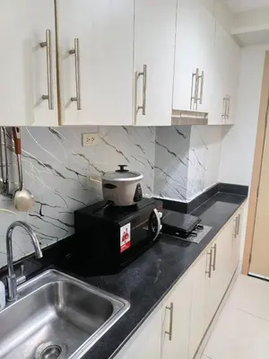 a kitchen with a sink and a pot on a toaster at Luxx Place in Manila