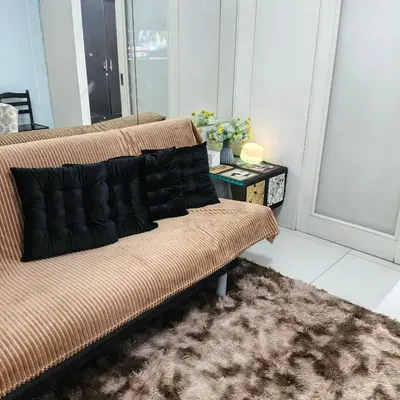 a couch with pillows on it in a living room at Luxx Place in Manila