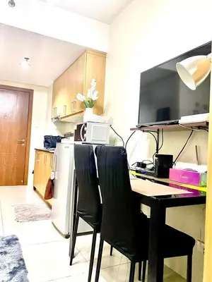 a kitchen with a table with chairs and a refrigerator at Queen Magzy Place in Manila
