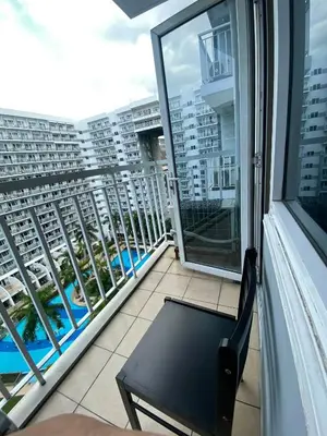 a balcony with a chair and a view of a building at Queen Magzy Place in Manila
