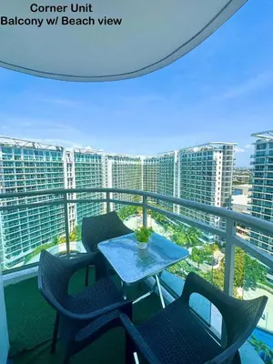a balcony with a table and chairs on a balcony with buildings at Deluxe penthouse unit at azure - near airport in Manila