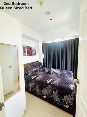 a bedroom with a bed with a black and brown queen sized bed at Deluxe penthouse unit at azure - near airport in Manila