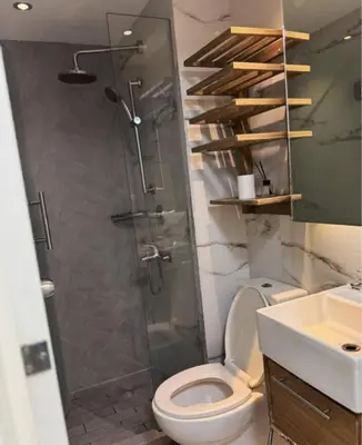 a bathroom with a shower and a toilet and a sink at Family room at azure - near airport in Manila