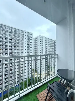 a balcony with a table and chairs and buildings at Cozy staycation near Mall of Asia in Manila