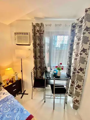 a bedroom with a desk and a window with a table at Luxurious Homey Suite IN FRONT of US Embassy Manila Bay in Manila