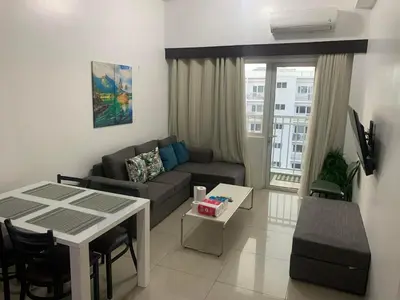 a living room with a couch and a table at Shore Residence by Buhay Staycation in Manila