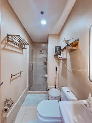 a bathroom with a toilet and a shower and a sink at FOG Staycation in Manila