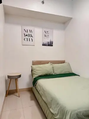 a bedroom with a bed and three pictures on the wall at FOG Staycation in Manila