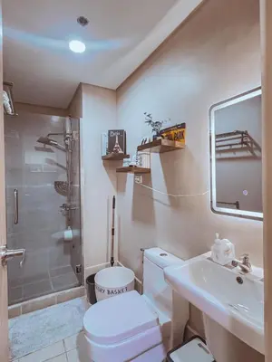 a bathroom with a toilet and a sink and a shower at FOG Staycation in Manila