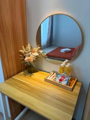 a table with a mirror and a table with flowers on it at Manila Flat Mall of Asia SMX city view with netflix in Manila