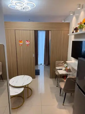 a room with two tables and chairs and a television at Manila Flat Mall of Asia SMX city view with netflix in Manila