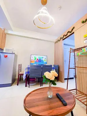 a living room with a table with a vase of flowers at SHORE 1 MALL OF ASIA Staycation in Manila