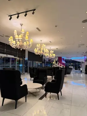 a lobby with chairs and a table and chandeliers at SYM staycation at Azure in Manila