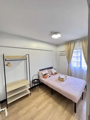 a bedroom with a bed and a mirror in it at Alea Residences 2 Bedroom Condo with Pool View Balcony in Manila
