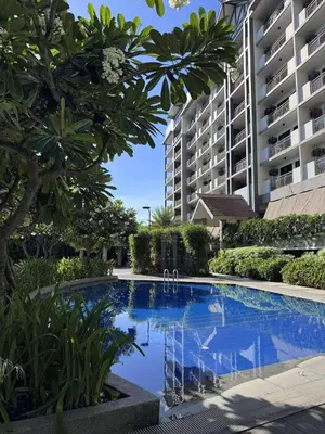 a large swimming pool in front of a building at Alea Residences 2 Bedroom Condo with Pool View Balcony in Manila