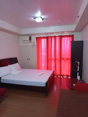 a bedroom with a bed and red curtains at Grand Soho Makati in Manila