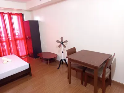 a room with a bedroom with a table and a bed at Grand Soho Makati in Manila