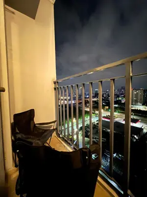 a balcony with a view of a city at night at Shore 2 Residences, Tower 1 in Manila