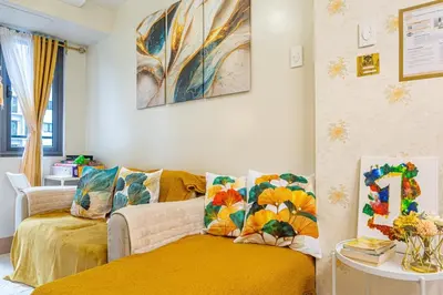 a living room with a couch and a yellow blanket at 1BR Near MOA Balcony & Wi-Fi in Manila