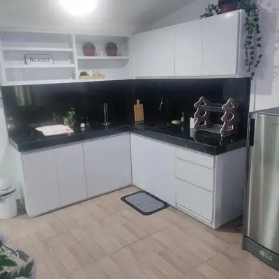 a kitchen with white cabinets and a black counter top at Cozy Private Retreat with Kitchen & Balcony in Bacoor