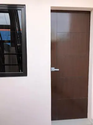 a wooden door in a white wall with a mirror at Wilabdaman manila in Manila