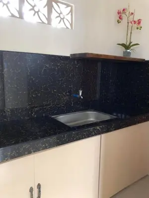 a kitchen with a black counter top and a sink at Wilabdaman manila in Manila