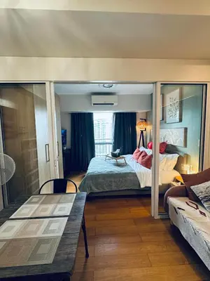 a bedroom with a bed with a person jumping in the air at Pahinga Luxury Stays in Manila