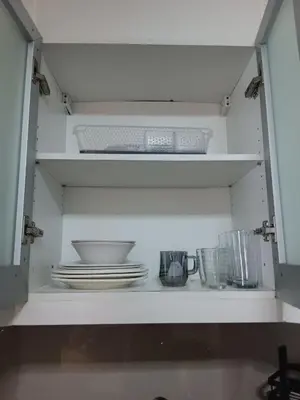 a kitchen shelf with plates and bowls and dishes at Cluster 1 9N in Manila