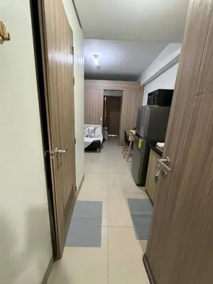 a hallway with a door and a room with a bed at Nordic Style 1br Shore 2 Residences Tower 3 in Manila