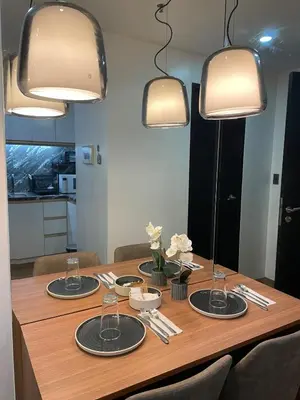 a dining room table with four plates and lights at 81 Newport Building across NAIA Terminal 3 C5-8C in Manila