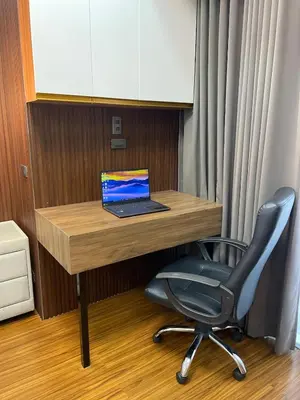 a laptop computer sitting on a wooden desk with a chair at 81 Newport Building across NAIA Terminal 3 C5-8C in Manila
