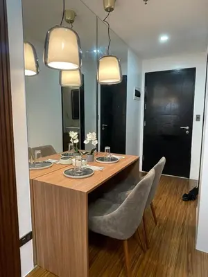 a dining room table with two chairs and two lights at 81 Newport Building across NAIA Terminal 3 C5-8C in Manila