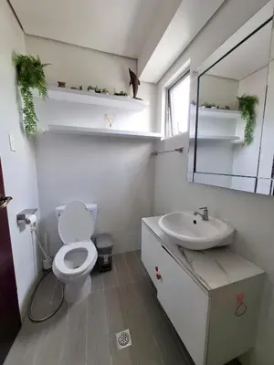 a bathroom with a toilet and a sink and a mirror at Cozy Hotel-Style 2 Bedroom Condo Unit at Eastbay Residences by Rockwell in Manila