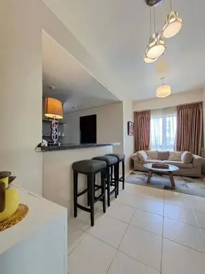 a living room with a couch and stools and a table at Cozy Hotel-Style 2 Bedroom Condo Unit at Eastbay Residences by Rockwell in Manila