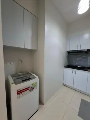 a small kitchen with a refrigerator and white cabinets at Cozy Hotel-Style 1 Bedroom Condo Unit Bryant Tower 12E at Eastbay Residences by Rockwell in Manila