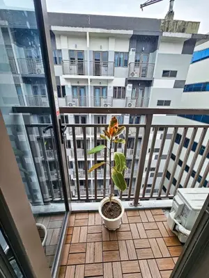 a plant in a pot on the balcony of a building at Haven Home in Manila