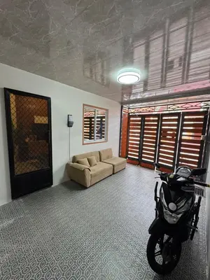 a living room with a couch and a motorcycle in it at Tan's Homestay in Trece Martires