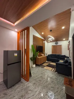 a living room with a couch and a tv at Tan's Homestay in Trece Martires