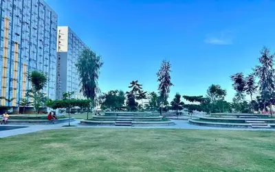 a park with benches and trees and a building at Malamaya Staycation in Manila