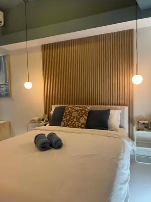 a bedroom with a large bed with two towels on it at Bleau Haven KL Service Residences Makati in Manila