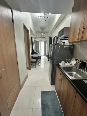 a kitchen with a sink and a refrigerator at Gateway mall of asia shore 3 near Airport Malls in Manila