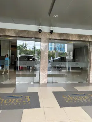 an airport lobby with glass doors and people walking around at Gateway mall of asia shore 3 near Airport Malls in Manila